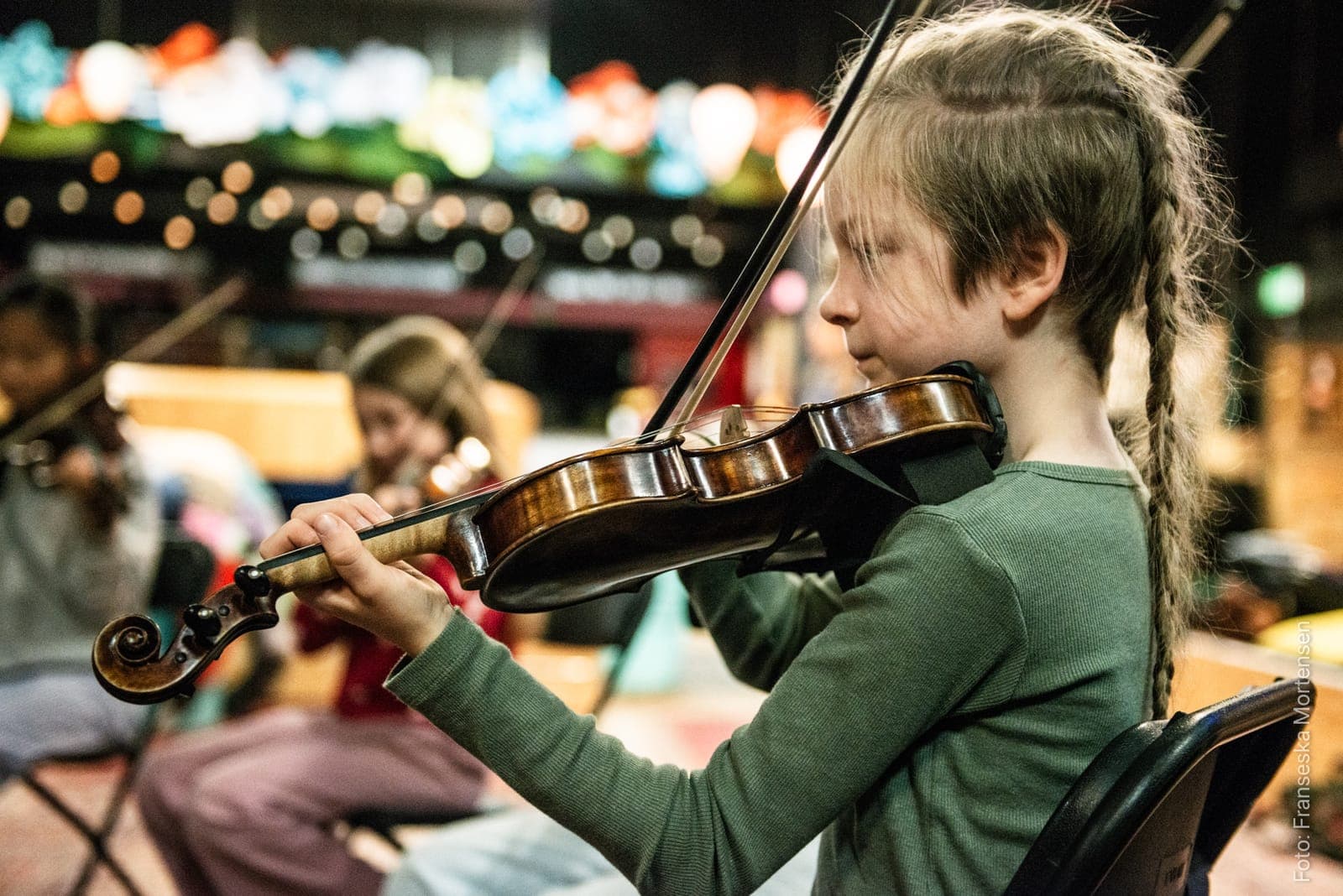 Et barn spiller violin i en workshop under Aarhus Folk Festival